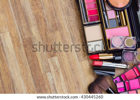 set of brushes, lipsticks, maskara, eye shadows with copy space on wooden table desktop