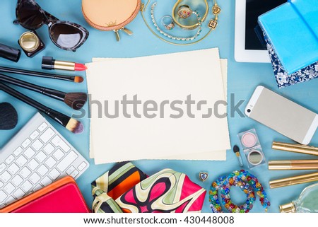 styled feminine desktop - woman fashion items on blue wooden background, copy space on aged photo paper