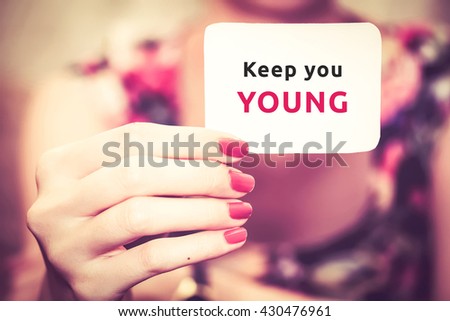 " Keep you young " text on card show by girl with pretty hand