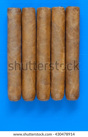 Detail of luxury Cuban cigars on the blue table