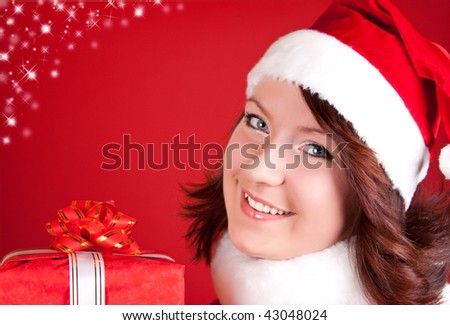 beautiful smiling girl in santa cloth holding a present