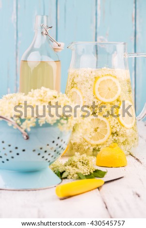Elderflower and lemon slices in a jug for making elderflower syrup.