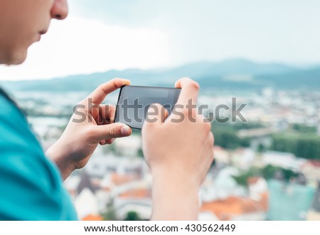 Close up image man hands with modern phone taking picture of city landscape