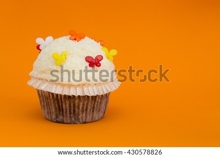 cupcake with butterflies on orange background