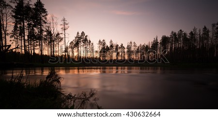 Swedish river photographed with long exposure at sunset, reflections in the water