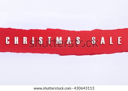 Torn paper with a CHRISTMAS SALE word on red background.
