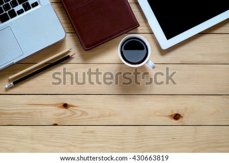 Designer desk with laptop,blank screen tablet,leather notebook, pencils and cup of coffee. Top view with copyspace. Flat lay image.Office supplies and gadgets on desk table.Working desk table concept.