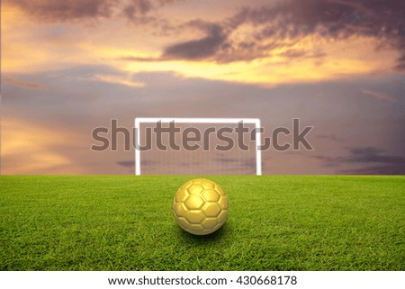 soccer ball on soccer field and blurred sky-clouds and sunlight
