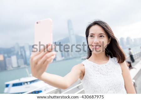 Woman take self picture in landmark of Hong Kong