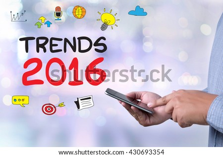 TRENDS 2016 person holding a smartphone on blurred cityscape background