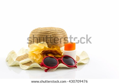 Woven hat with body lotion and red sunglasses on white background.