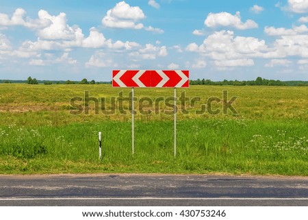 Red road sign with green field on the background