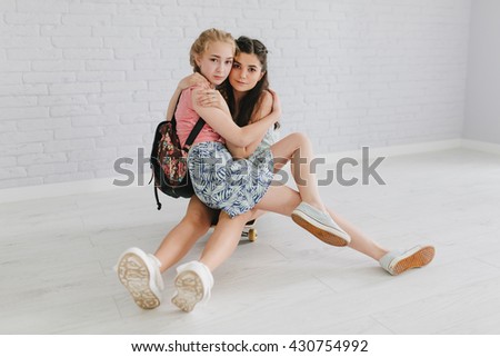 Two teen girls on the skateboard make selfie.