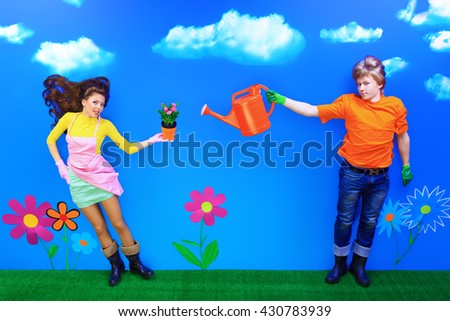 Couple of young people in love standing with flowers in their hands. Fantasy world.
