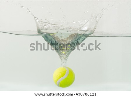 Throwing tennis ball into the aquarium with water