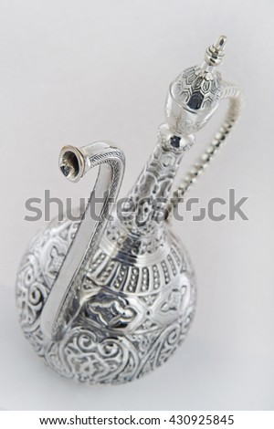 silver jug on a white background, Close up photo of handmade silverware that is delicately handcrafted, Custom made authentic designs are the key factor in getting the fine art made.