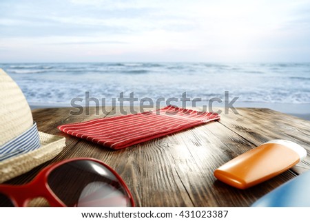 blue landscape of ocean with waves and red napkin wooden table and bottles of oil 
