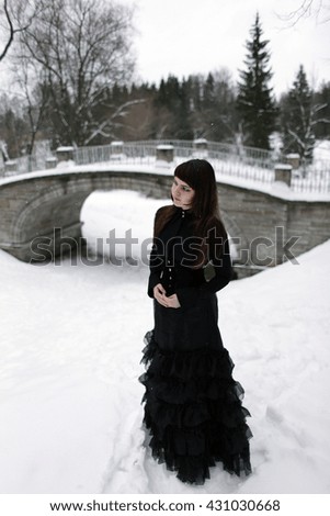 Young girl black long dress bridge background