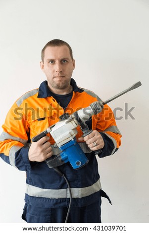 The photo depicts a worker with hammer