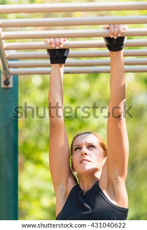 Rung to rung exercise on monkey bar by female