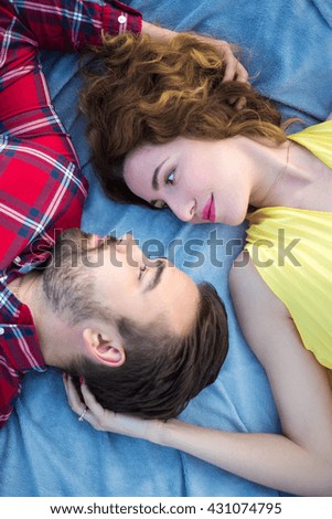 top view close up portrait of young beautiful couple lying on blanket