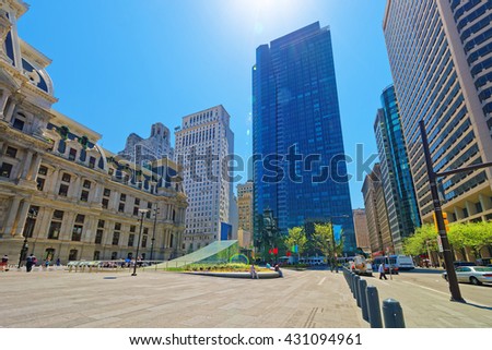 Penn Square with Philadelphia City Hall and skyline of skyscrapers. Tourists on the square. Pennsylvania, USA. With special sun flare