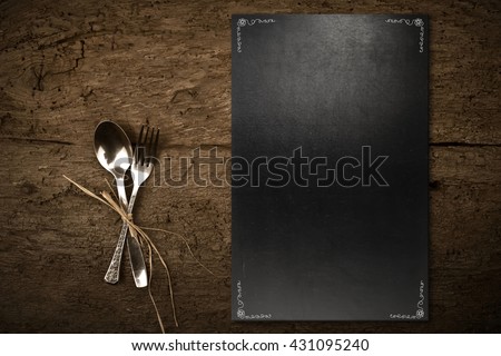 Vintage slate chalkboard template menu and spoon and fork on dark wooden background Royalty-Free Stock Photo #431095240