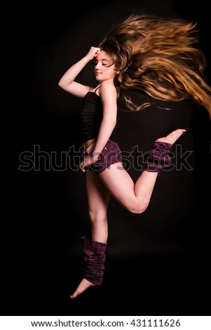 modern dancer poses in front of the black wall
