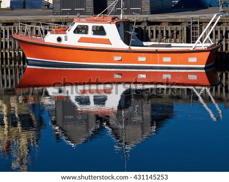 Reflection of a modern motorboat in the sea water of a marina