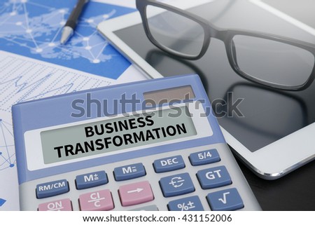 BUSINESS TRANSFORMATION Calculator  on table with Office Supplies. ipad