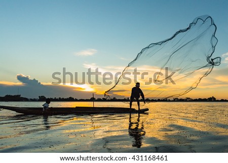 silhouette photo.
The old fisherman casting the net for fish to cook for a little grandson in the sunset. Royalty-Free Stock Photo #431168461