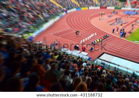 Start on 100m sprint. Professional athletes on stadium are on start blocks and the are ready to race. Royalty-Free Stock Photo #431188732
