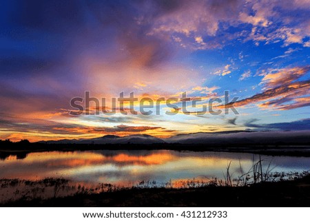 Colorful sky during sunset over the lake, cloud bursting with reflection