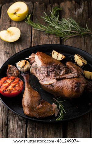 Roast duck with apples and rosemary in a frying pan