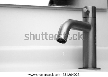 Faucet with water drop (Close up with selective focus and rough monotone picture)