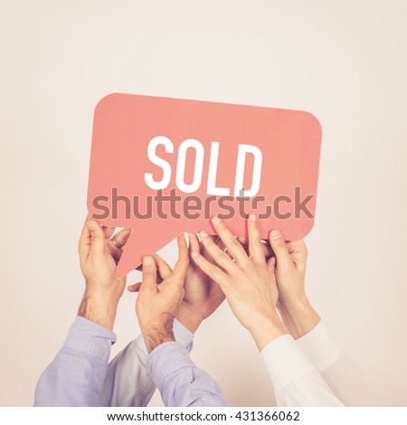 A group of people holding the Sold written speech bubble