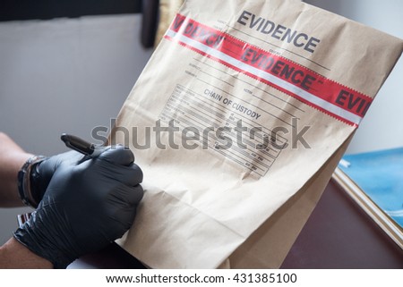 forensic 's hand in black glove writing on evidence bag and seal by red tape in crime scene investigation Royalty-Free Stock Photo #431385100