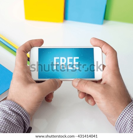 Man holding smartphone which displaying Free