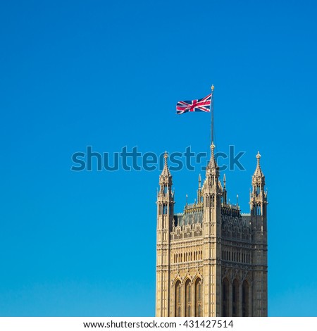 British national flag on top of Parliament building with blue sky