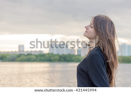 beautiful girl in a town near the lake on the sunset background