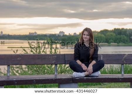beautiful girl in a town near the lake on the sunset background