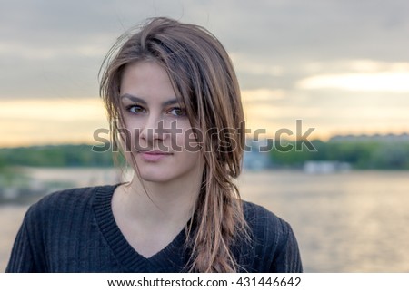 beautiful girl in a town near the lake on the sunset background 