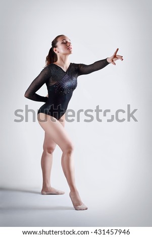 full length portrait of young gymnast on neutral background in photostudio