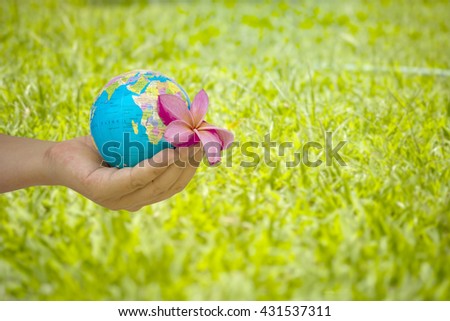 hand male gesture holding the world against blur of green background, human hands with healthy world concept, love and safe conception.