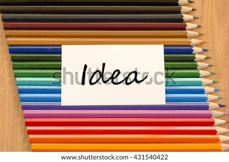 Idea text concept and colored pencil on wooden background
