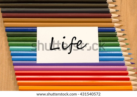 Life text concept and colored pencil on wooden background