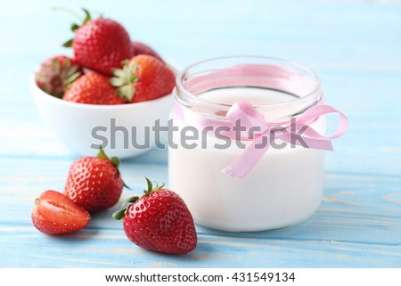 Strawberry yogurt in glass on wooden table