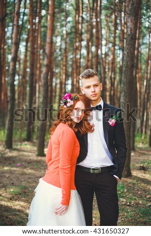 Wedding shot of bride and groom in park. Wedding couple just married with bridal bouquet.  Young couple in love outdoor.