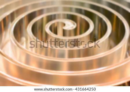 Metal spiral polished metal. Abstract background. Toning in the color golden metal. Deep blur.