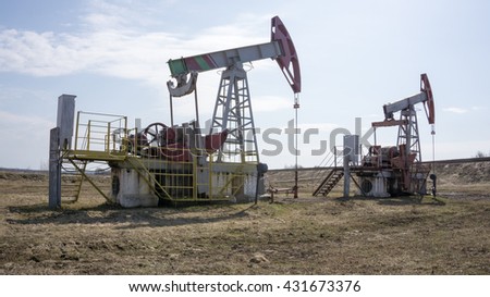 Oil pumps. Oil rocking chair. Oil industry equipment. Oil rocking chair closeup. Oil rocking chair on a background of blue sky. The pumping unit as the oil pump installed on a well.